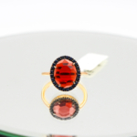 Dettaglio pregiato dellanello Pomellato con granato e zaffiri su fondo in oro rosa 18 kt ketercomprooro