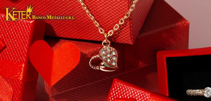 Collana in oro con ciondolo a cuore e diamanti e anello con diamante, perfetti come idee regalo per San Valentino, presentati su confezioni regalo rosse con decorazioni romantiche.